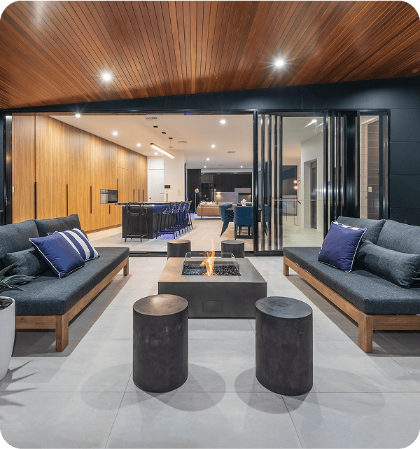 Modern indoor outdoor living space with stylish seating, a fire pit, and contemporary decor, designed to enhance home comfort and aesthetics. Perfect for entertaining or relaxing in a luxurious setting.