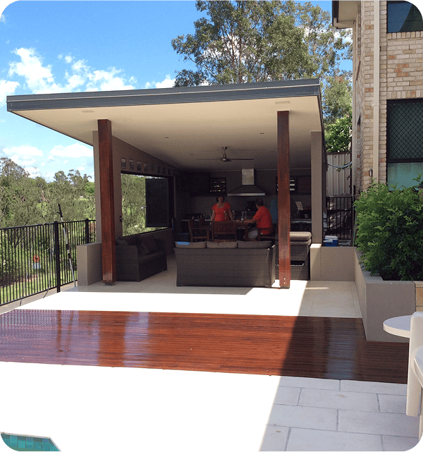 Modern outdoor living space with a stylish covered patio, outdoor kitchen, and scenic backyard view, perfect for entertaining and relaxation.