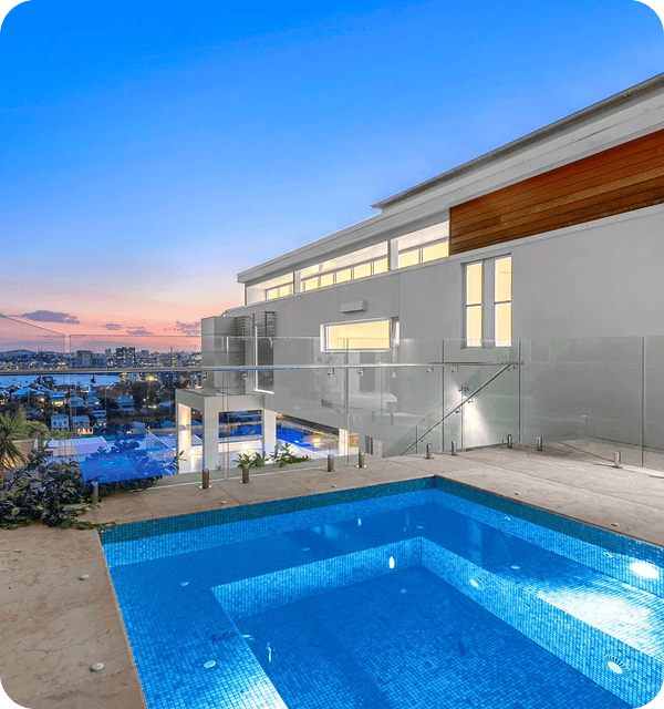 Luxury modern house with rooftop pool overlooking city skyline at sunset, showcasing stylish architecture and outdoor living space in Australia.