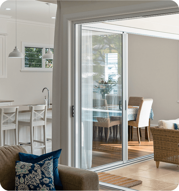 Sliding glass door leading to dining area and outdoor patio, modern home interior with natural light.