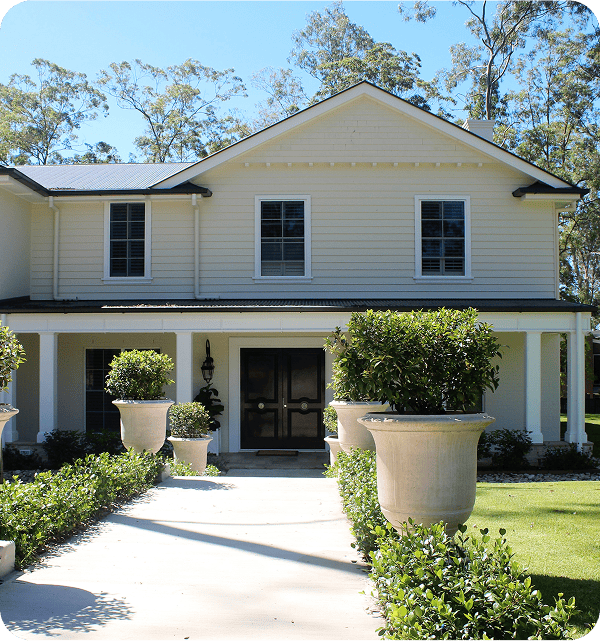 Modern two-storey white house with black accents and manicured front garden, showcasing a beautiful residential property.