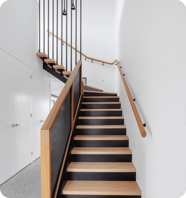 Black and wooden staircase with modern railing in contemporary interior design, showcasing stylish home renovation and building improvements.